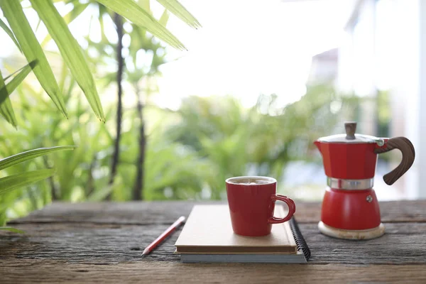 Red coffee cup and red moka pot and notebook