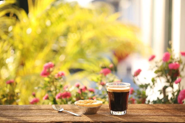 Kopi Dalam Cangkir Kaca Dan Telur Tart Dan Bunga Luar — Stok Foto