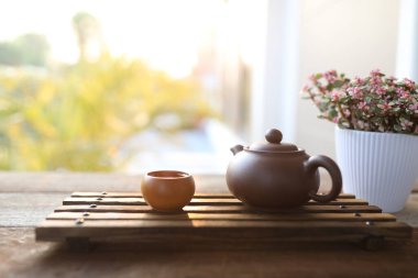 Toprak çaydanlık, küçük çay fincanı ve ahşap tepside Portekiz afrası.