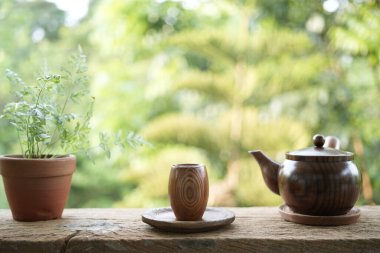 Tahta küçük çay fincanı ve toprak kap ve ahşap masa üzerine bitki ve açık hava içme
