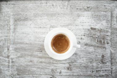 Grunge ahşap masada beyaz bir fincanda kahve düzleşmişti.