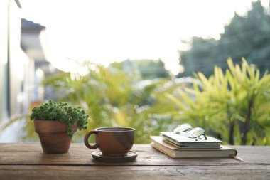 Kahverengi çay fincanı ve çaydanlık. Kahverengi saksı, defterler ve bardaklar.