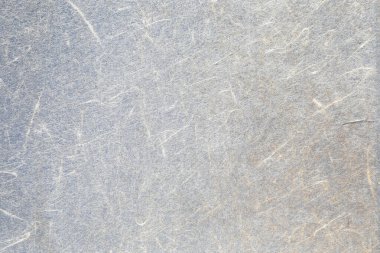 Kaba, eski, sararmış, çizik desenli bir kağıt.