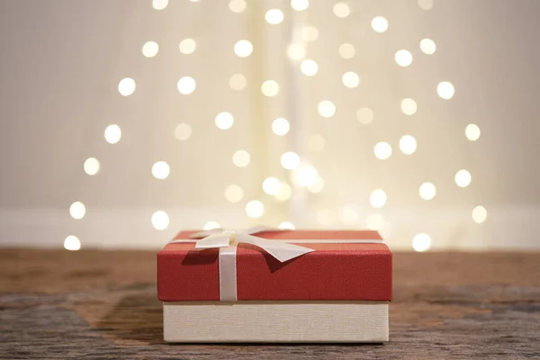 Red gift box with white light bulb bokeh background