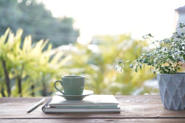 Mavi antika kahve fincanı ve günlük defterleri ve serin çaydanlık serinletici içecekler.