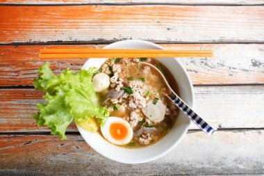 Haşlanmış domuz eti, yumurta ve ahşap masa.