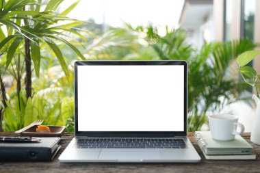 Dizüstü bilgisayar, defter, kahve fincanı, ahşap masa, bahçe işlerinde rahatlama.