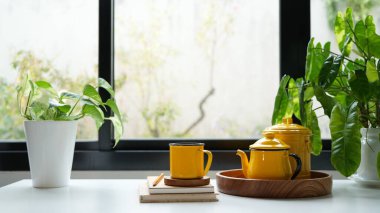 Sarı çay demliği ve bardak seti, kapalı mekanda içmek.