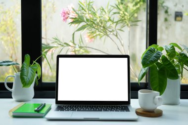 Beyaz ekran ve kahve içen dizüstü bilgisayar, kapalı çalışma alanı