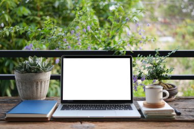 Laptop ve kahve fincanlı defterler, şehir balkonunda çalışma alanı