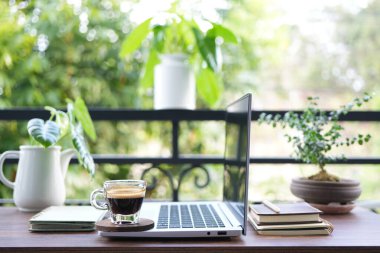 Kahve ve dizüstü bilgisayar manzaralı soğuk balkon çalışma alanı