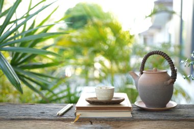 Kadim çaydanlık, çay fincanı ve defter, rahat balkon çalışma alanı