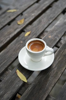 Koyu grunge ahşap masada küçük kahve fincanı.