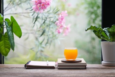 Portakal suyu bardağı ve defterler, iç mekan yazma ayarları.