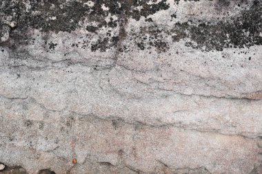 Dalgalı çapraz yatak dokusu ve siyah lekeleri olan doğal taş duvar.