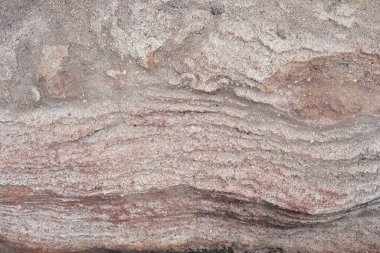 Dalgalı çapraz yatak dokusu olan doğal kırmızı kaya duvarı.