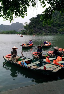 Ninh Binh, Vietnam - 07 Nisan 2018: Vietnam 'daki Trang An turistik bölgesinde kadınlar kürek çekiyor.
