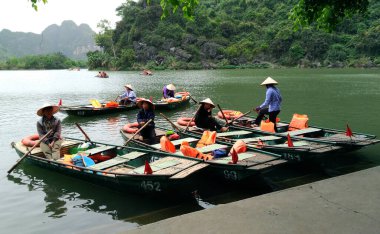 Ninh Binh, Vietnam - 07 Nisan 2018: Vietnam 'daki Trang An turistik bölgesinde kadınlar kürek çekiyor.