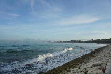 Güzel mavi gökyüzü, gün doğumu, kumsal ve sabah Kuta sahilinin etrafındaki beyaz kumlar..