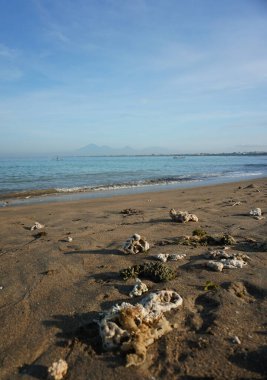 Güzel mavi gökyüzü, gün doğumu, kumsal ve sabah Kuta sahilinin etrafındaki beyaz kumlar..