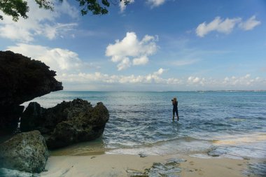 Bir kadın Endonezya, Blai 'de Jimbaran bölgesinde güzel bir plajı ziyaret ediyor..