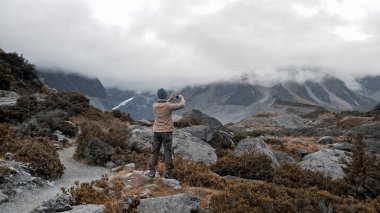 Bir adam Yeni Zelanda 'daki Cook Ulusal Parkı' ndaki fahişe vadisi patikasında yürüyor..