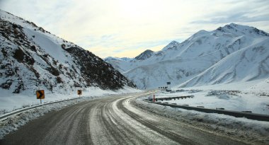 Yeni Zelanda 'nın güneyindeki bir yolculuğa çıkan doğal güzellik. Dağlar, ağaçlar ve yol boyunca açık gökyüzü.