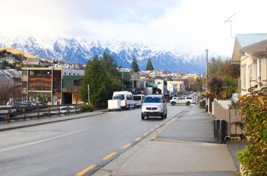 Yeni Zelanda 'nın güneyindeki bir yolculuğa çıkan doğal güzellik. Dağlar, ağaçlar ve yol boyunca açık gökyüzü.