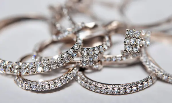 Aydınlık arkaplanda farklı kesiklere ve boyutlara sahip elmaslara yaklaş. Bir sürü güzel elmas. 3 boyutlu görüntü. Hafif arkaplan.