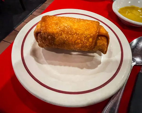 Wantagh, NY - USA - July 22, 2023 Horzontal view of a classic Cantonese Fried Eggroll on a plate.