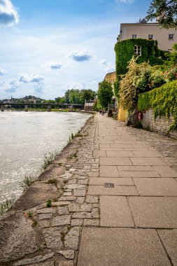 Passau, Aşağı Bavyera - d. 6 Haziran 2023 Passaus 'un Inn Nehri' nin zümrüt yeşili suları boyunca yürüdüğü dikey manzara