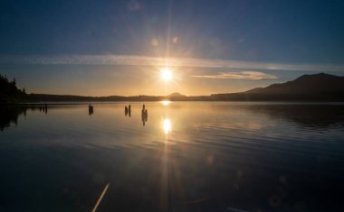 Quinault, WA-USA 20 Eylül 2021: Olimpiyat Ulusal Parkı 'ndaki Quinault Gölü üzerinde gün batımının yatay görüntüsü.
