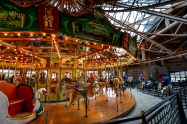 Bear Mountain, New York - ABD - 30 Aralık 2023 Bear Mountain State Park 'taki konukların atlıkarınca turunun keyfini çıkardıkları iç mekan. Atlıkarınca 'da park sahneleri ve yerli hayvanların el oyması koltukları yer alıyor..