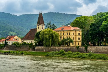 Ossatz-Arnsdorf, Aşağı Avusturya - AT - 8 Haziran 2023 Hofarnsdorf ve Hofarnsdorf Şatosu 'ndaki Kutsal Rupert kilisesinin manzaralı manzarası Tuna Nehri boyunca inşa edildi..