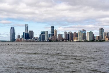 New York, New York - ABD - 19 Mayıs 2024 Jersey City silueti görüntüsü; Hudson Nehri 'nin karşısındaki Waterfront Finans Merkezi, Exchange Place, Goldman Sachs Tower ve 99 Hudson Caddesi' nin altını çiziyor..