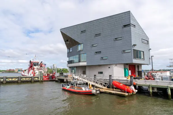 stock image New York, NY  US  May 19, 2024 The striking FDNYs Marine Company 1 firehouse, designed by CDR Studio Architects in 2009. Proving docking for The 343 fireboat and other smaller vessels