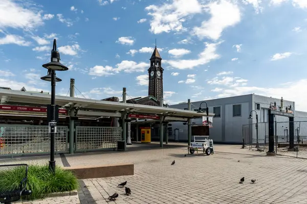 stock image Hoboken, NJ - US - June 7, 2024 View of the brick promenade linking New Jersey Light Rail platforms to Hoboken Terminal, its historic charm complemented by the iconic Terminal tower in the distance.