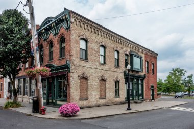 Coxsackie, New York - ABD - 5 Temmuz 2024 Reed Caddesi ve S. River Caddesi 'nin köşesinde, kemerli camları ve karmaşık tuğlaları olan 19. yüzyılın ortalarında bir ticari bina..