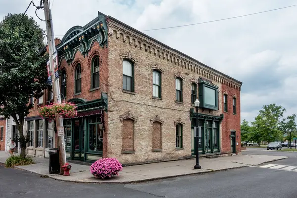 stock image Coxsackie, NY - US - July 5, 2024 A mid-19th century commercial building on the corner of Reed St and S. River St in the Reed Street Historic District, with arched windows and intricate brickwork.