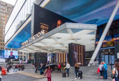 New York, NY  US  Sep 26, 2024The sleek entrance to Penn Station in New York City, with bright digital screens, modern design elements, and people walking or entering the station clipart