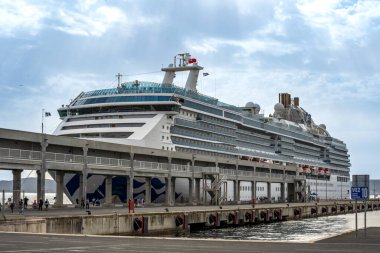 Zadar HR 17 Ekim 2024 Hırvat bayrağı, kırmızı, beyaz ve mavi çizgilerini ülkenin ayırt edici kareli kalkanı ve beton bir duvara karşı amblemiyle gururla dalgalandırıyor.