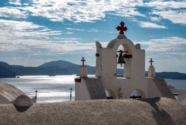 Santorini, Güney Ege GR 20 Ekim 2024 Yunanistan 'ın Santorini kentindeki Oia köyünün dingin güzelliği, Ege Denizi' ne tepeden bakan kırmızı aksanlı geleneksel bir beyaz boyalı çan kulesine ev sahipliği yapıyor.
