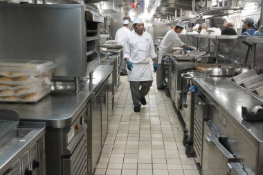 Adriyatik Denizi - 24 Ekim 2024 Ada Prensesi 'nin mutfağında aşçılar verimli bir şekilde çalışarak düzenli istasyonları ve profesyonel takım çalışması olan lekesiz, paslanmaz çelik bir mutfakta yemek hazırlıyorlar..