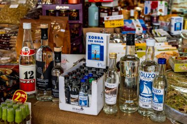 Atina, Attica - GR - 25 Ekim 2024 Atina 'da, uzo, mastiha, tsipouro ve aperatifler gibi Yunan spesiyalitelerinin yer aldığı canlı bir dükkan, yerel tatlar ve kültürel cazibe sergileniyor..