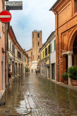 Ravenna - IT - 16 Ekim 2024 Ravenna, İtalya 'da hoş bir kaldırım taşı caddesi, sıcak tonlu tuğla binalar, butik dükkanları ve açık hava kafeleri tarafından çevrelenmiş, barışçıl ve zamansız bir atmosfer yayıyor.