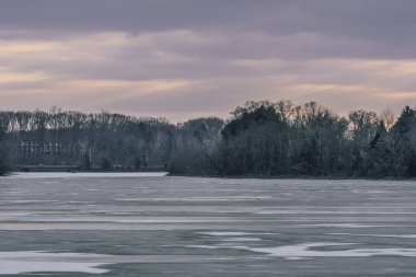 Blauvelt, New York - ABD - 12 Ocak 2025 Tappan Gölü 'nün üzerindeki günbatımı, New York ve New Jersey' de uzanan sakin bir rezervuar, gökyüzünü turuncu ve mor renkleriyle boyar, dingin sularına yansıtır.