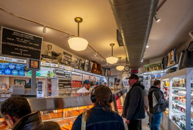 New York, New York - ABD - 25 Ocak 2025 Russ and Daughters 'tan müşteri alışverişi, füme balık, simit ve havyarla bilinen tarihi bir NYC iştah açıcı dükkanı,.