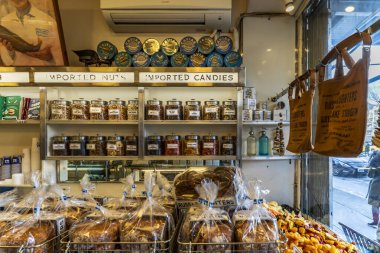 New York, New York - ABD - 25 Ocak 2025 Russ and Daughters, rafları fındık, şeker ve havyar sergilenen tarihi bir NYC mezat dükkanı. Fırınlanmış yiyecekler, kurutulmuş meyveler ve markalı çantalar görülebilir..
