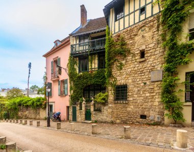 Paris, FR - Sep 11, 2016 4 Rue de l'Abreuvoir in Montmartre, Paris, is a charming 1920s residence with ivy-covered stone walls. It was once home to Henry Lachouque, a WWI officer and historian. clipart