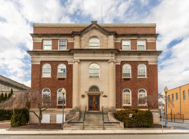 Middletown, New York - ABD - Middletown Sanat Merkezleri 'nin 1 Aralık 2025 Büyük sütunları ve kırmızı çift kapılı tarihi taş binası bir sokak köşesinde duruyor